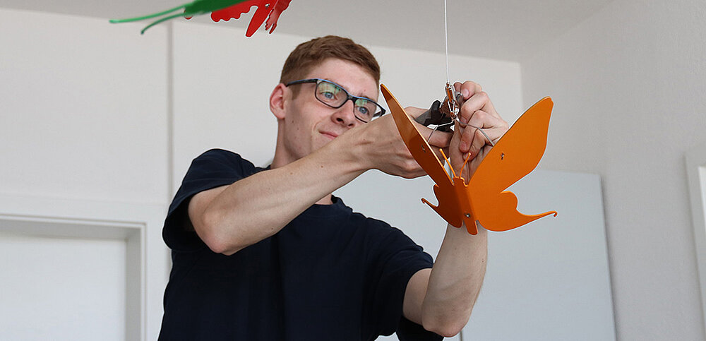 Montage eines Schmetterlings aus pulverbeschichtetem organgefarbenem Metall